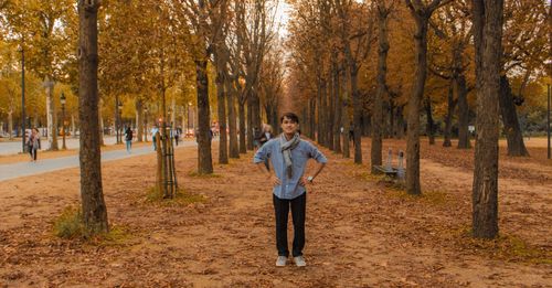 Portrait of man standing amidst trees in park