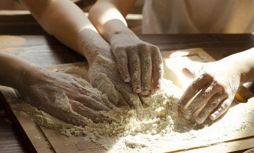 Children's hands preparing food with a flour