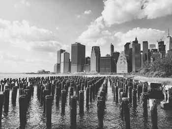 Panoramic shot of wooden posts in sea against sky