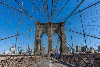 Low angle view of suspension bridge against blue sky