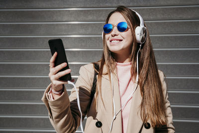 Smiling young woman using mobile phone