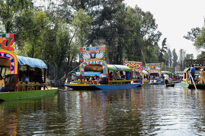 People on riverbank against sky