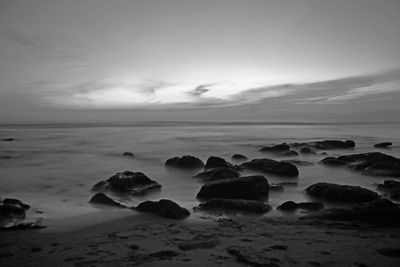 Rocks on beach against sky