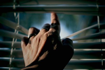 Close-up of human hand next to window