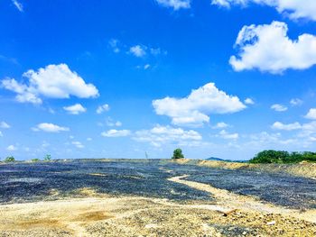 Scenic view of beach against blue sky