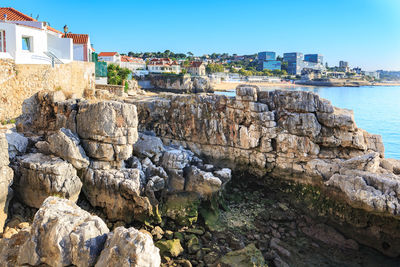 Buildings by rocks against sky