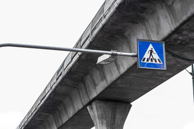 Low angle view of road sign against bridge