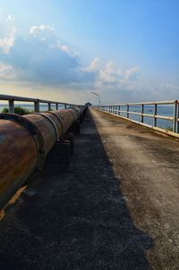 View of footpath leading towards sea against sky