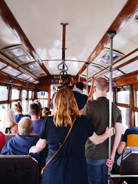 Rear view of people standing in bus