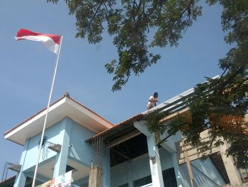 Low angle view of worker on incomplete building with indonesian flag