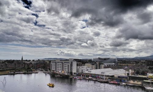 Buildings in city against cloudy sky