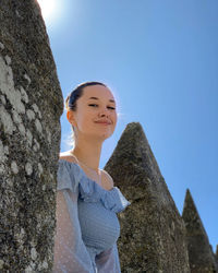 Low angle view of woman standing against clear sky