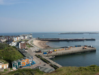 High angle view of city by sea against clear sky