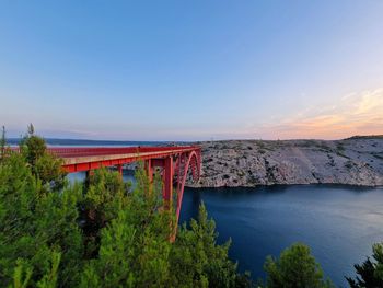 Bridge over river against clear blue sky