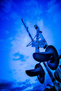 Low angle view of crane against blue sky