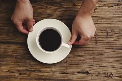 Cropped image of woman holding coffee cup