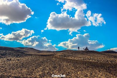 Scenic view of desert against blue sky