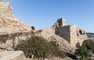 Low angle view of fort against clear blue sky