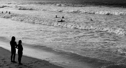 People at beach against sky