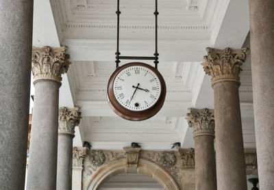 Low angle view of clock hanging on ceiling