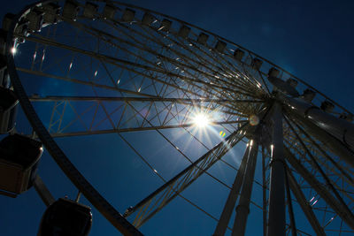 Low angle view of ferris wheel against blue sky