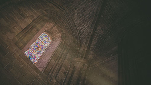 Low angle view of stained glass window in building