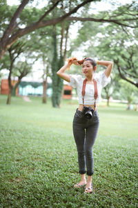 Full length of young woman  tied her hair, camera around her neck, beautiful woman photographer