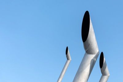 Low angle view of sculpture against clear blue sky