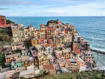 High angle view of townscape by sea against sky