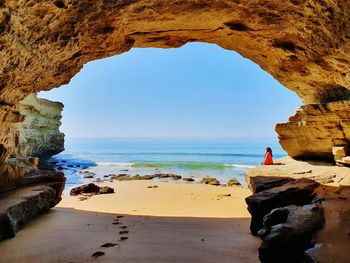 Rock formation on beach against sky