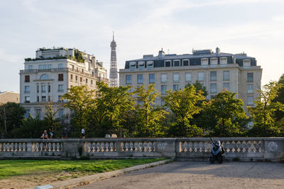 Trees and buildings against sky in city