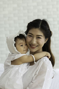 Portrait of cheerful mother with daughter at home