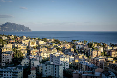 High angle view of townscape by sea against sky