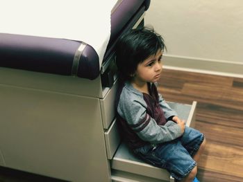 Boy sitting on bed at hospital