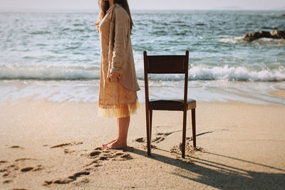 Rear view of woman standing on beach