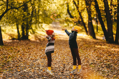 Rear view of woman with umbrella during autumn