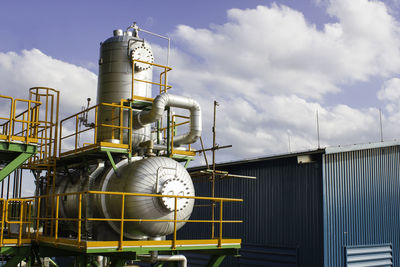 Low angle view of industry against sky