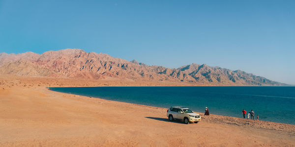 Scenic view of desert against clear blue sky