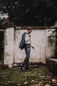 Side view of man standing against plants