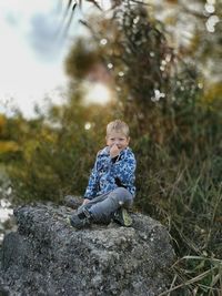 Boy sitting on a rock