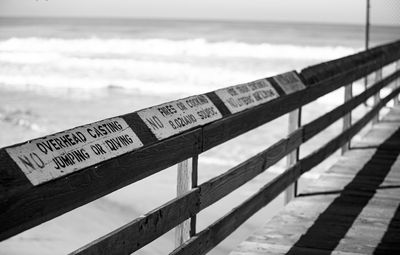 Text on railing against sea