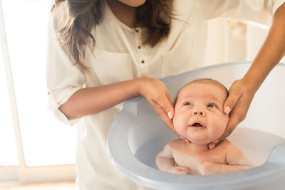 Mother bathing son in bathtub at bathroom