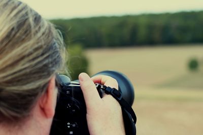 Rear view of woman holding camera