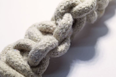 Close-up of rope tied on white background