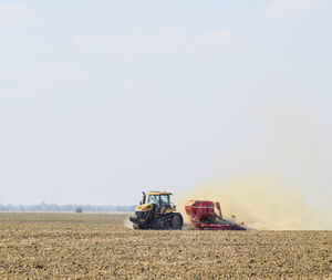 Tractor working on field against clear sky