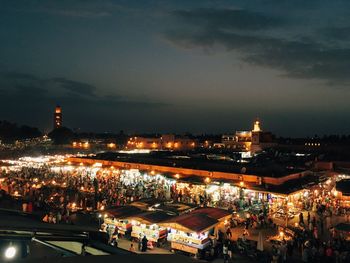 People shopping in city against sky at night