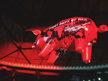 Low angle view of illuminated carousel hanging in amusement park