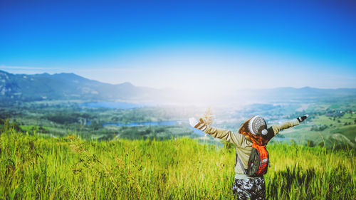 Rear view of woman standing against mountain