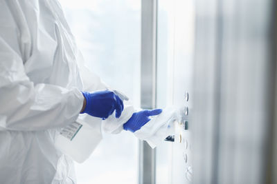 Midsection of person cleaning elevator