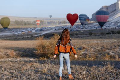 Rear view of woman standing on field